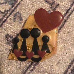 Pin depicting two adult and two children